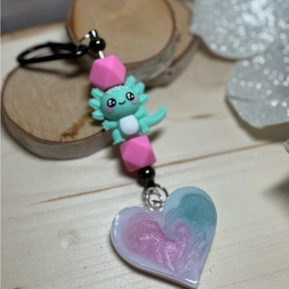 axolotl keychain with a pink and teal or blue resin heart pendant